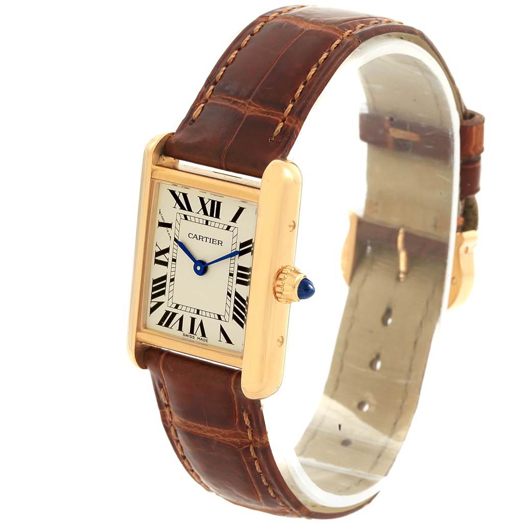 The Cartier Tank Louis W1529856 Women's Yellow Gold Silver Dial W1529856 Women's Yellow Gold Silver Dial watch is shown at a slight angle, displaying its face, brown leather strap, and golden bezel with a blue cabochon crown.