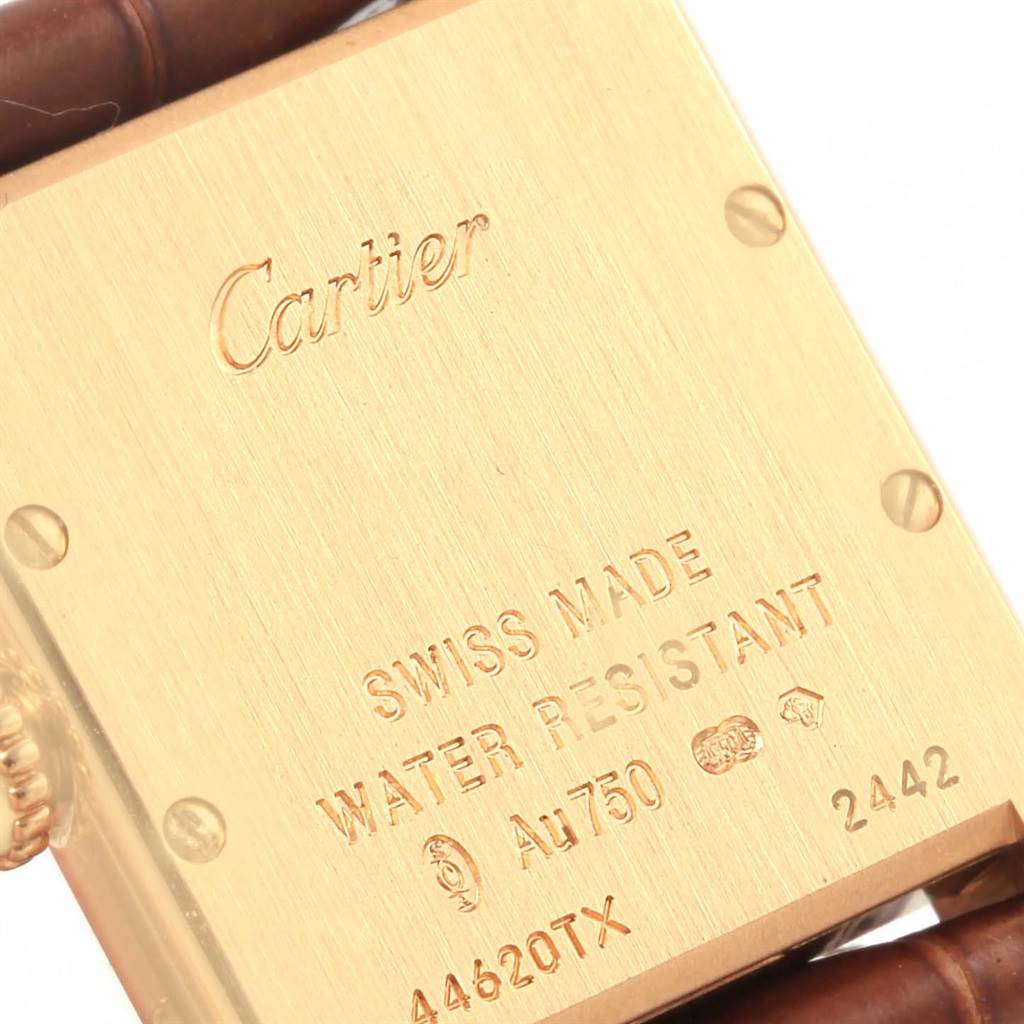 This image shows the back of a Cartier Tank Louis W1529856 Women's Yellow Gold Silver Dial W1529856 Women's Yellow Gold Silver Dial watch, highlighting its engravings and leather strap.