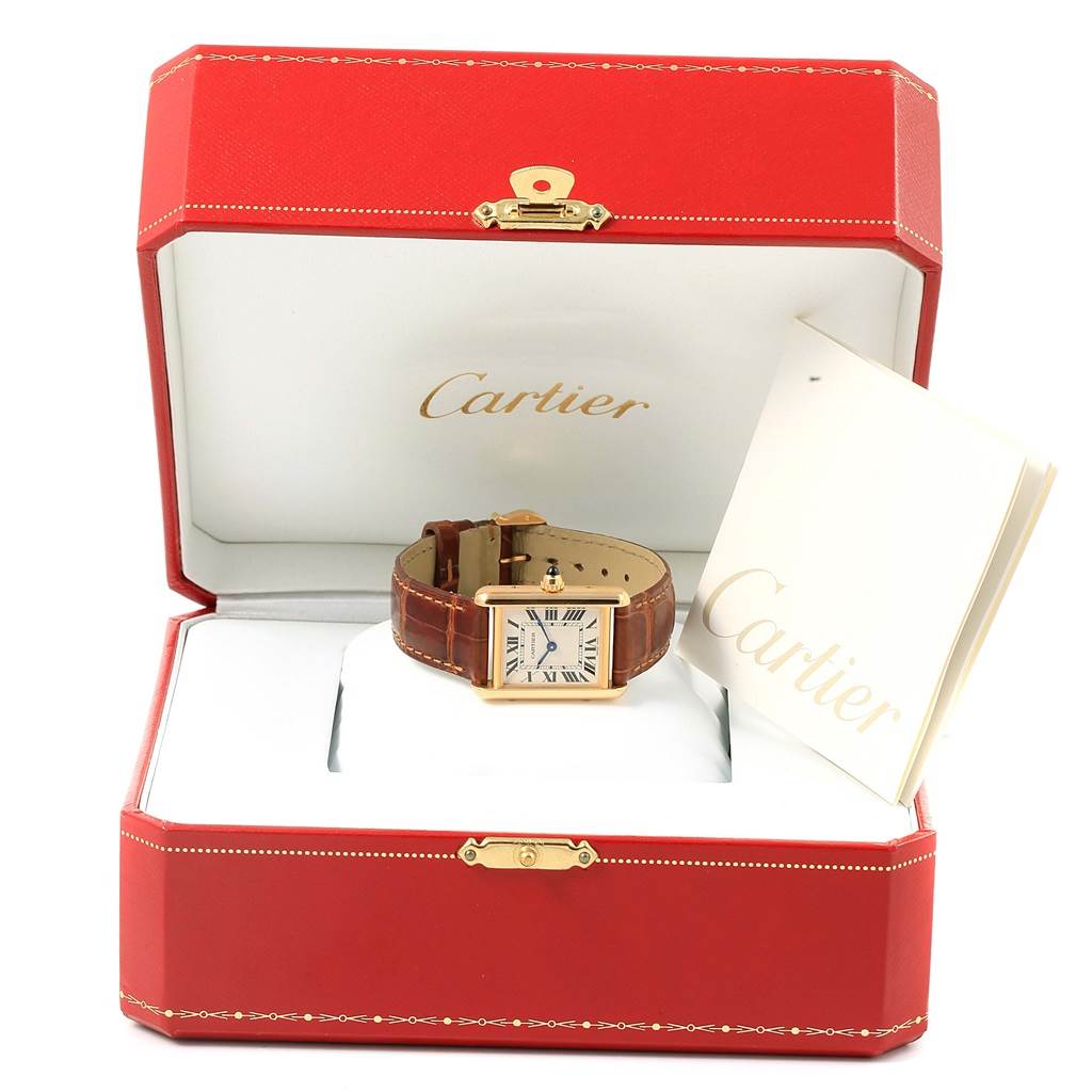 The Cartier Tank Louis W1529856 Women's Yellow Gold Silver Dial W1529856 Women's Yellow Gold Silver Dial watch is shown front-facing in an open Cartier box with a booklet beside it.