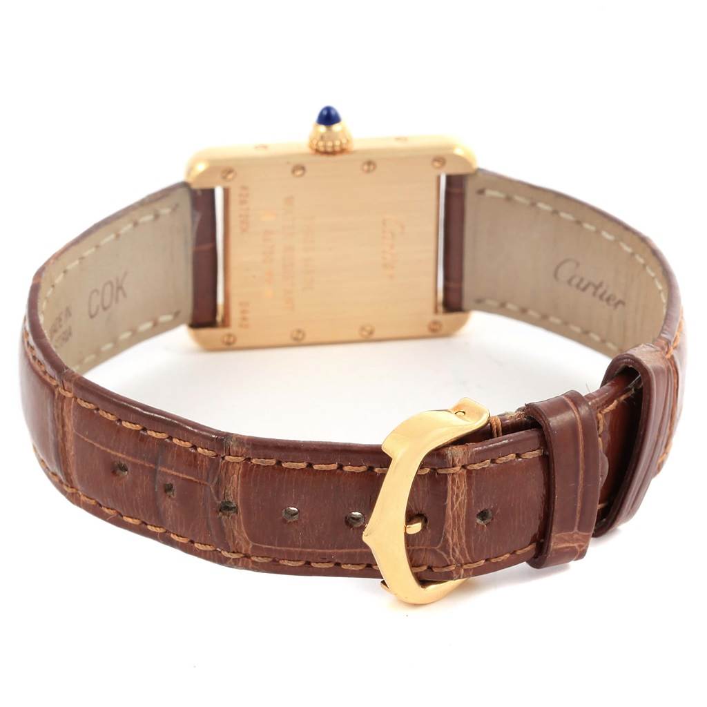 The image shows the back view of a Cartier Tank Louis W1529856 Women's Yellow Gold Silver Dial W1529856 Women's Yellow Gold Silver Dial watch, highlighting its leather strap and gold buckle.