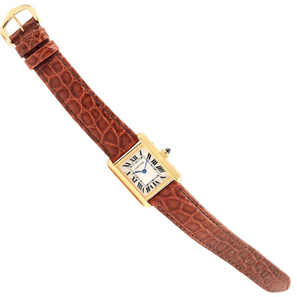 The Cartier Tank Louis W1529856 Women's Yellow Gold Silver Dial W1529856 Women's Yellow Gold Silver Dial watch is shown at a slight diagonal angle, displaying its brown leather strap, gold case, and rectangular dial.