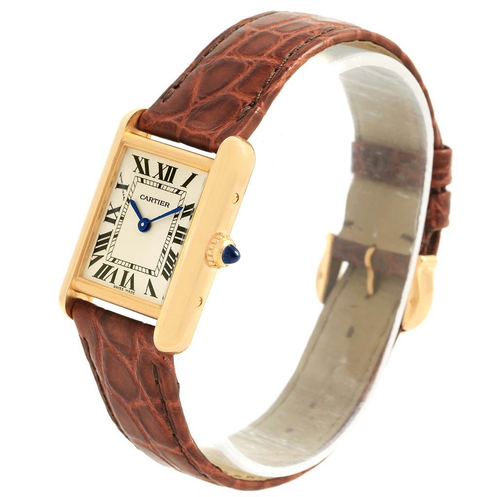 The Tank Louis model watch by Cartier is shown at an angled side view, showcasing its face, crown, and leather strap.