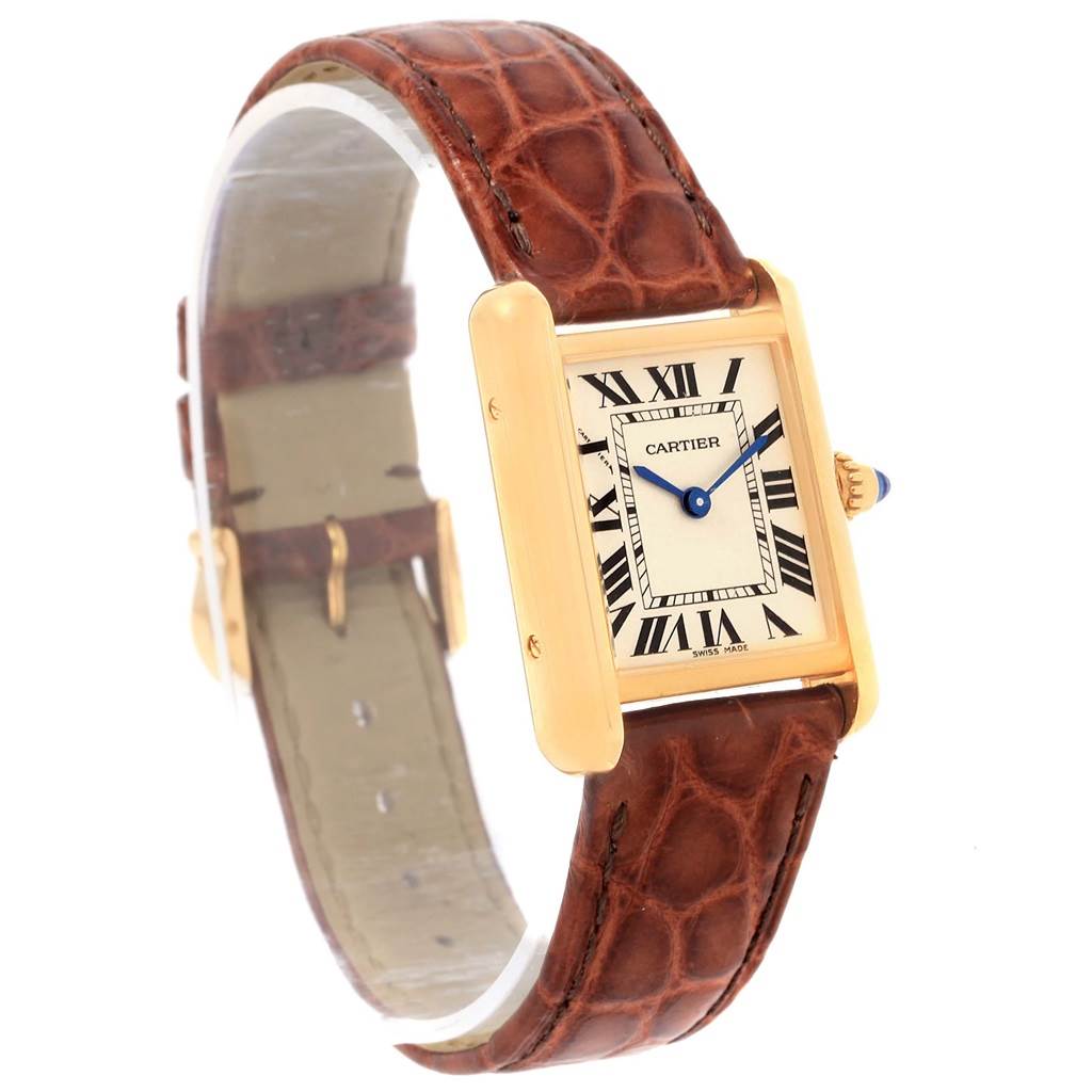 The Cartier Tank Louis W1529856 Women's Yellow Gold Silver Dial W1529856 Women's Yellow Gold Silver Dial model watch is shown at an angle, highlighting its rectangular face, brown leather strap, and gold casing.