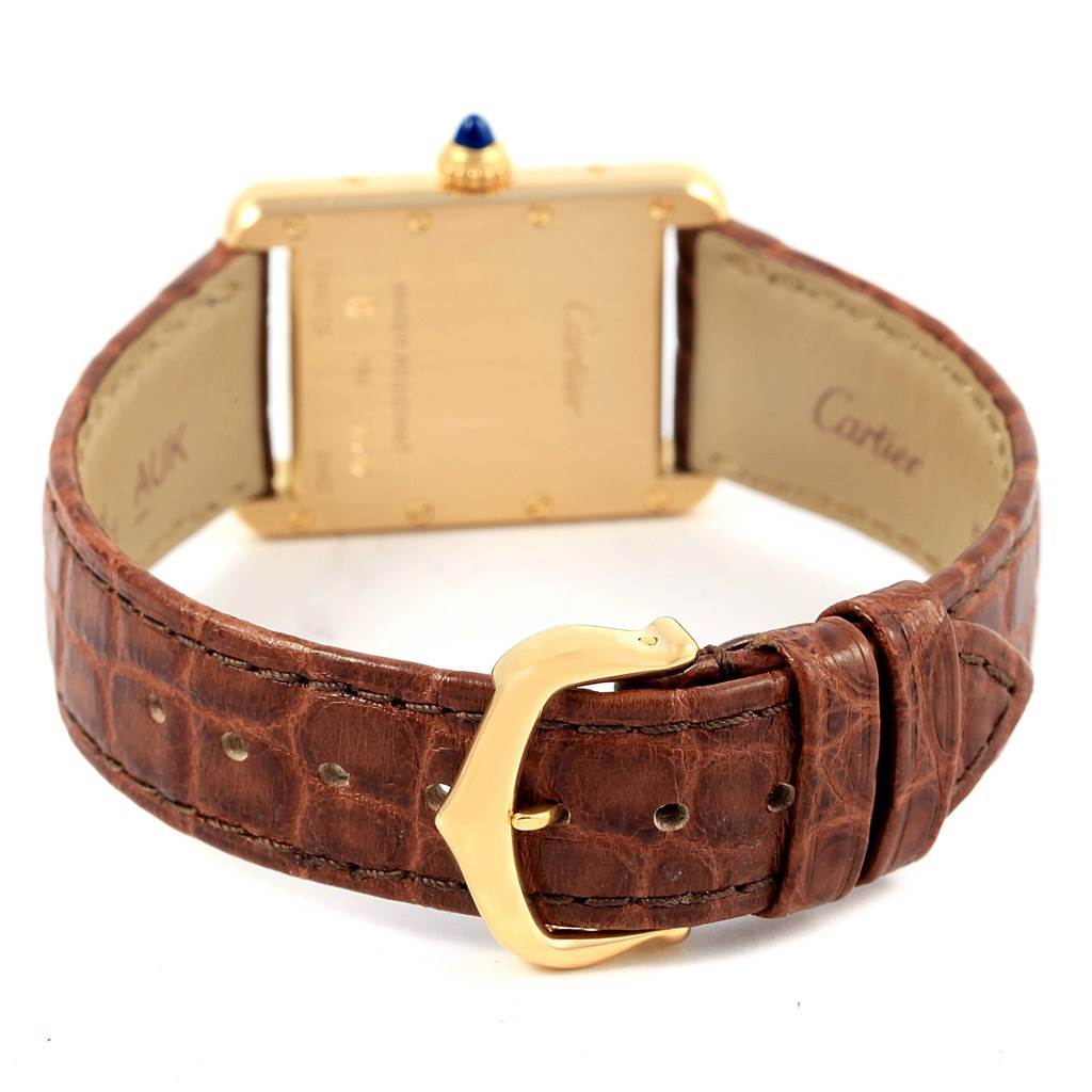 The image shows the back and clasp of a Tank Louis model by Cartier, highlighting the leather strap and buckle.