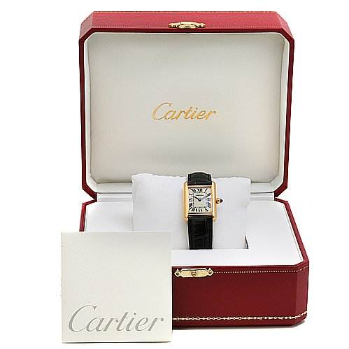 The Cartier Tank Louis W1529856 Women's Yellow Gold Silver Dial W1529856 Women's Yellow Gold Silver Dial watch is displayed in an open box with a booklet in the foreground, showcasing the dial and strap.