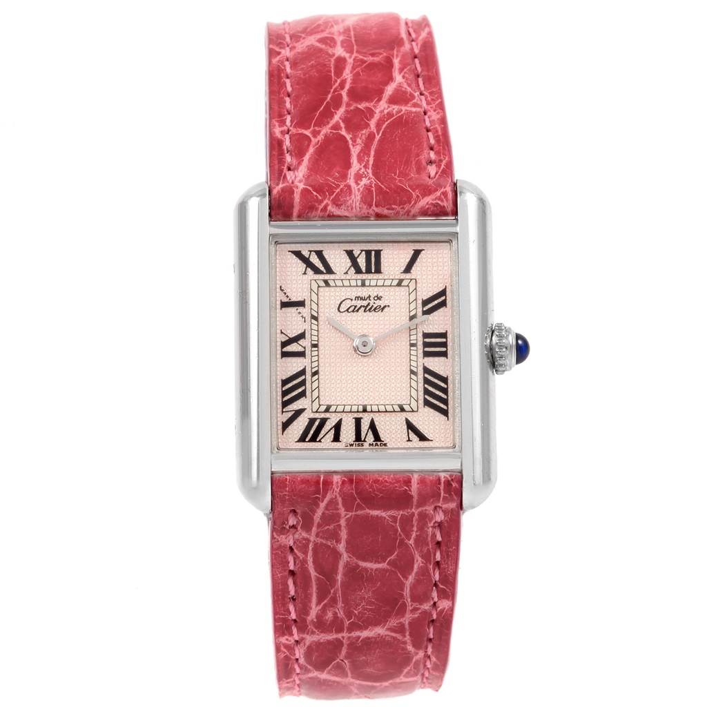The image shows a Tank Louis watch by Cartier from the front, highlighting its rectangular face, pink dial, and red strap.