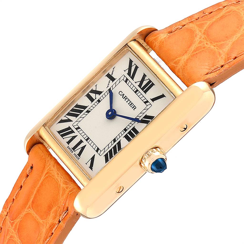 The Tank Louis model by Cartier is shown at a slight angle featuring its face, crown, and orange leather strap.