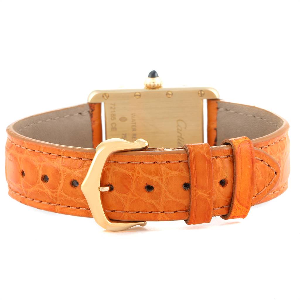The image shows the back and strap of the Cartier Tank Louis W1529856 Women
s Yellow Gold Silver Dial W1529856 Women
s Yellow Gold Silver Dial watch with its orange leather band and gold buckle.