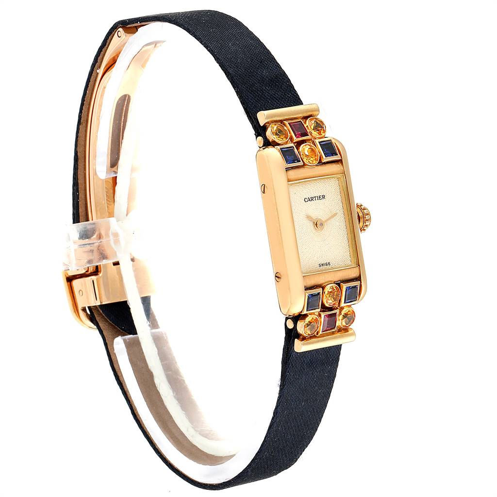 The Tank Louis Cartier watch is shown at a slight angle, highlighting its rectangular face, gem-set bezel, crown, and black strap.