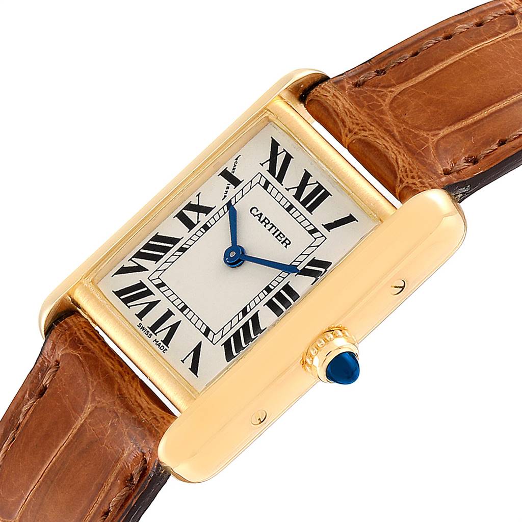 The Cartier Tank Louis W1529856 Women
s Yellow Gold Silver Dial W1529856 Women
s Yellow Gold Silver Dial watch is shown at an angled side view, highlighting its gold case, dial, and brown leather strap.