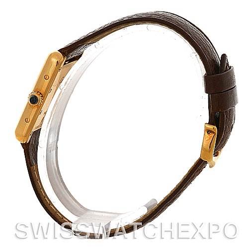 Side profile of a Cartier Tank Louis W1529856 Women's Yellow Gold Silver Dial W1529856 Women's Yellow Gold Silver Dial watch showing its rectangular case, crown with blue cabochon, and leather strap.