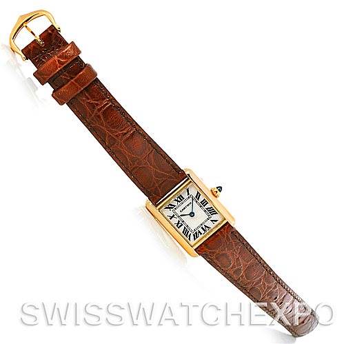 The image shows an overhead view of the Tank Louis watch by Cartier, including the rectangular watch face and the brown leather strap.