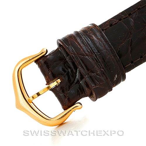 The image shows a close-up of the Tank Louis Cartier watch's brown leather strap and gold buckle.