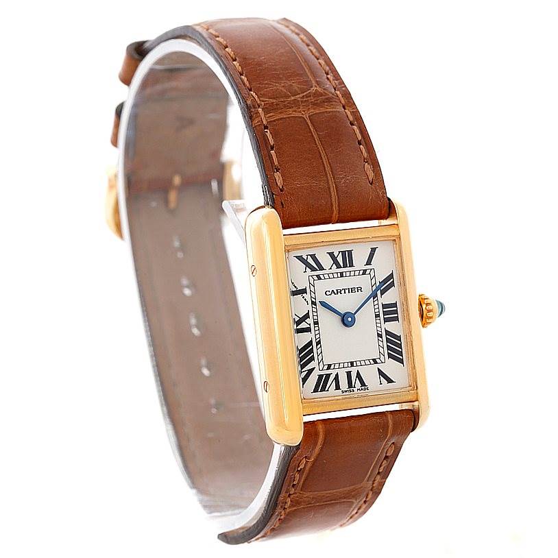 The image shows a Cartier Tank Louis W1529856 Women's Yellow Gold Silver Dial W1529856 Women's Yellow Gold Silver Dial model watch from an angle displaying the face, brown leather strap, and gold rectangular case.