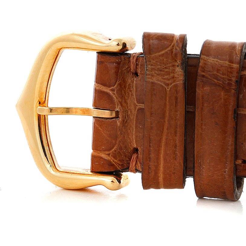 This image shows a close-up of the golden buckle and brown leather strap of a Cartier Tank Louis W1529856 Women's Yellow Gold Silver Dial W1529856 Women's Yellow Gold Silver Dial watch.