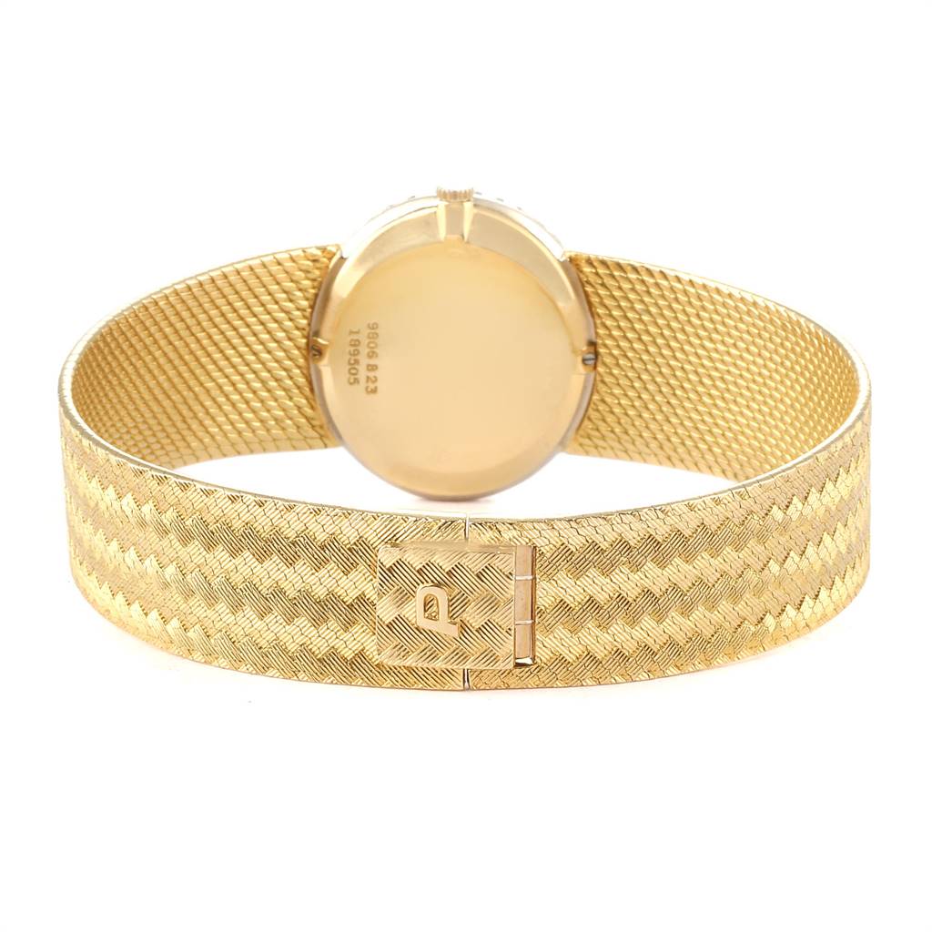 The image shows the back view of the Piaget 9806 Women
s Yellow Gold Champagne Dial 9806 Women
s Yellow Gold Champagne Dial 9806 18k Yellow Gold Diamond Ladies Watch, highlighting its patterned band and clasp.