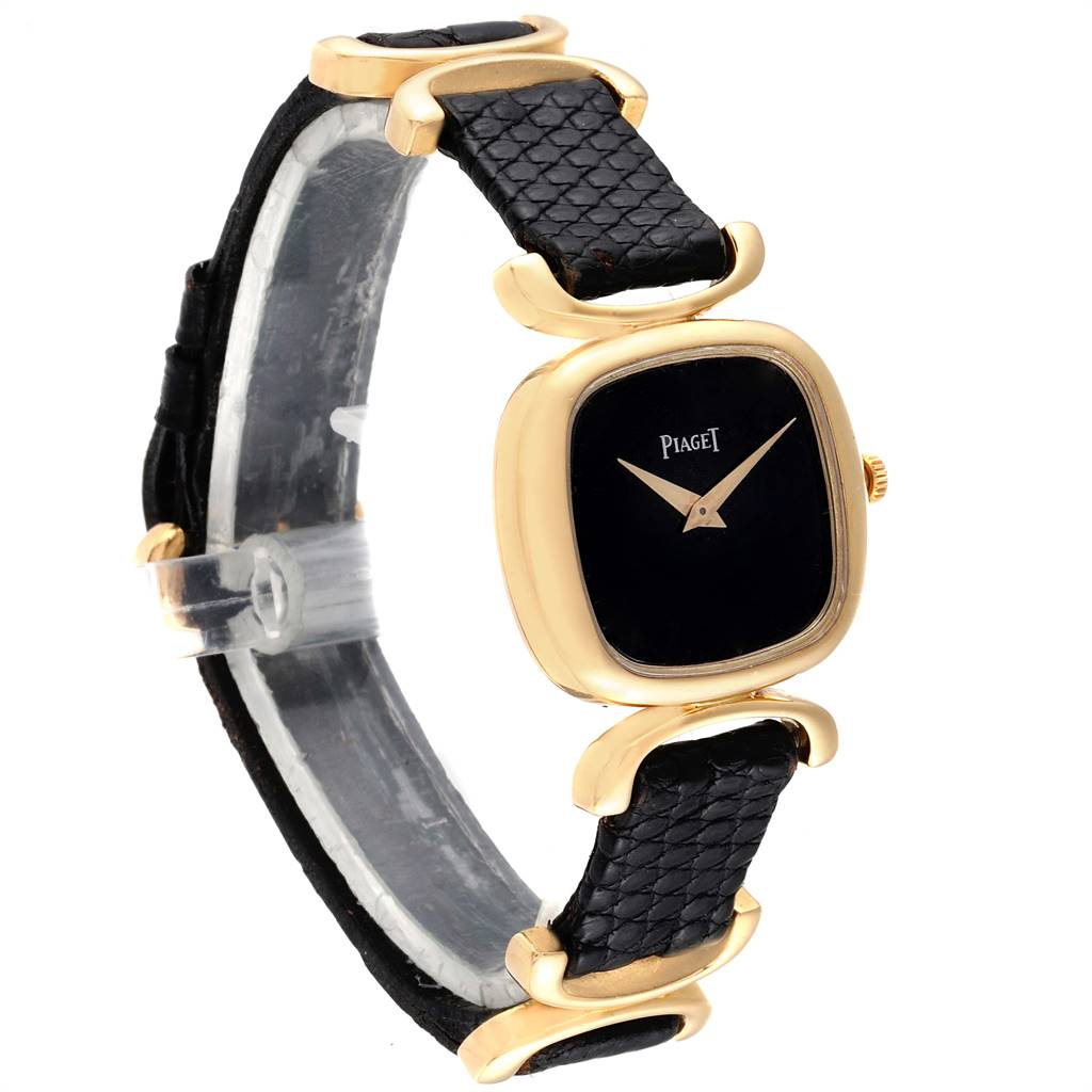 The image shows the Piaget 9451 Women's Yellow Gold Black Dial 9451 Women's Yellow Gold Black Dial Solo Tempo Yellow Gold Black Onyx Dial Vintage Ladies Watch 9451 from an angled side view showcasing the black strap and gold case.