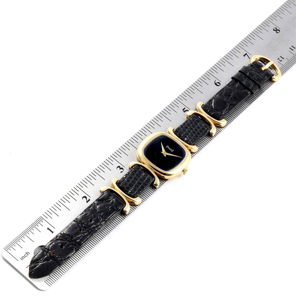 The Piaget 9451 Women's Yellow Gold Black Dial 9451 Women's Yellow Gold Black Dial Solo Tempo Yellow Gold Black Onyx Dial Vintage Ladies Watch 9451 model is shown lying flat with a ruler for scale.