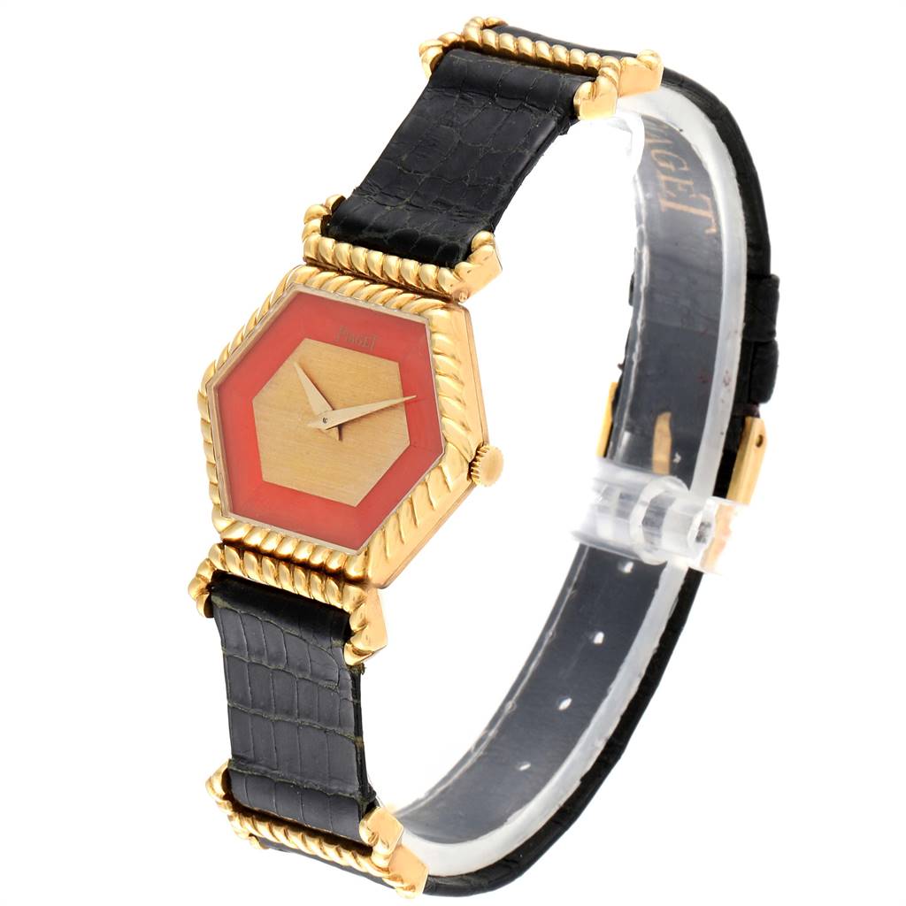 The image shows a Piaget 9559 Women's Yellow Gold Pink Dial 9559 Women's Yellow Gold Pink Dial 9559 model 18K Yellow Gold Coral Dial Hexagonal Vintage Ladies Watch at a three-quarter angle, highlighting the dial, case, and strap.