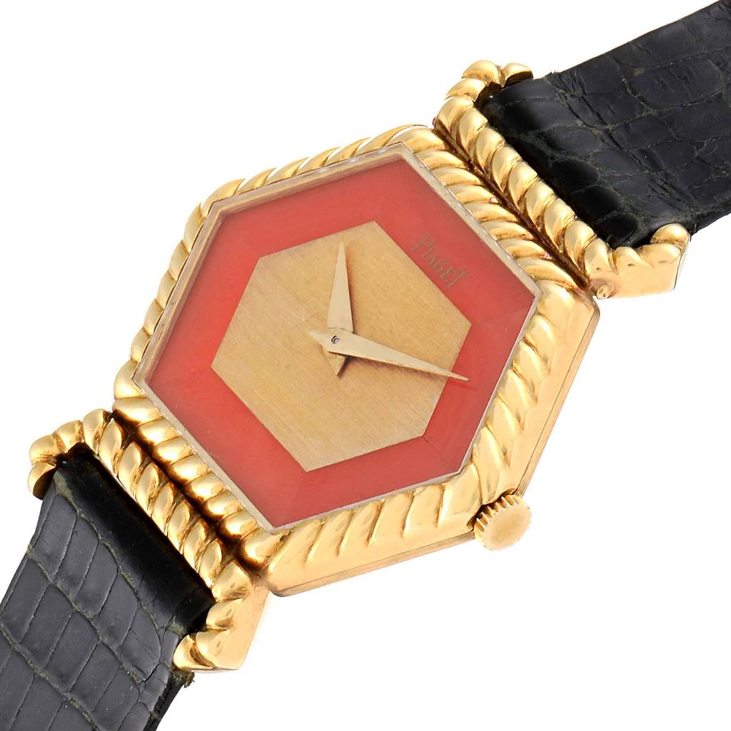 The image shows a close-up angle of a Piaget 9559 Women's Yellow Gold Pink Dial 9559 Women's Yellow Gold Pink Dial 9559 model, highlighting the 18K yellow gold case, hexagonal coral dial, and black leather strap.