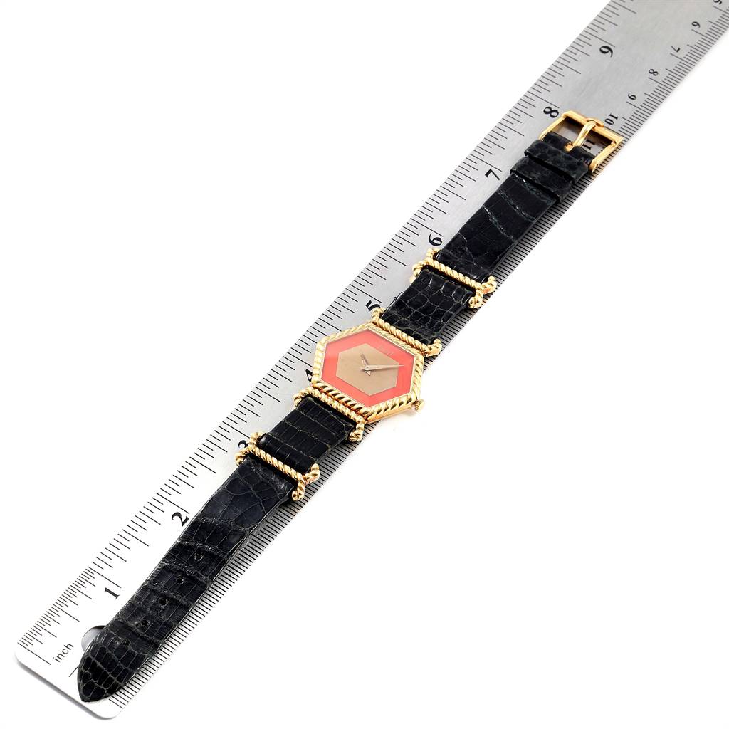 The image shows a top-down view of the Piaget 9559 Women's Yellow Gold Pink Dial 9559 Women's Yellow Gold Pink Dial 9559 model watch, displaying its hexagonal coral dial and black strap, with a ruler for scale.