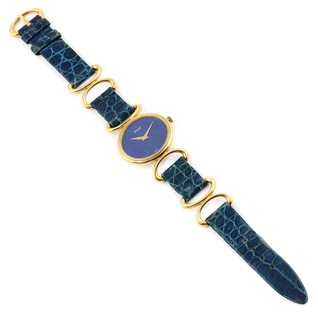 The image shows a top-down view of the Piaget 9451 Women's Yellow Gold Blue Dial 9451 Women's Yellow Gold Blue Dial Classique Yellow Gold Lapis Dial Vintage Ladies Watch 9451, featuring its blue strap and gold accents.