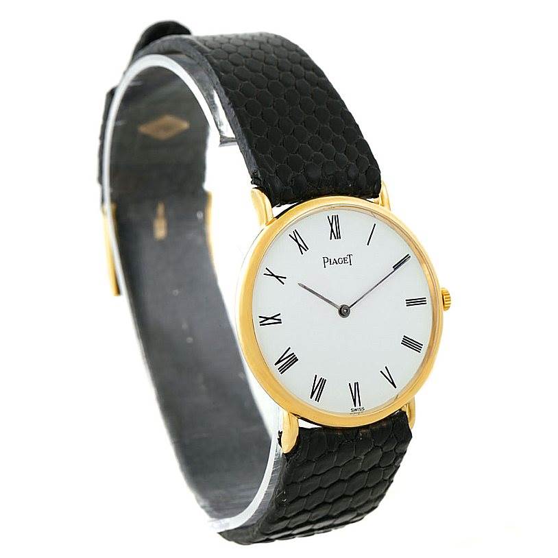 This image shows a Piaget 9025 Men's Yellow Gold White Dial 9025 Men's Yellow Gold White Dial 9025 18K Yellow Gold Mechanical Men's Watch at a slight side angle, highlighting its round dial and black leather strap.