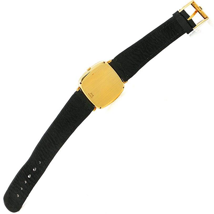 This image shows the back view of a Piaget Men's Yellow Gold Black Dial Men's Yellow Gold Black Dial 18K Yellow Gold Cushion Shape Mechanical Men's Watch, displaying its strap and case back.