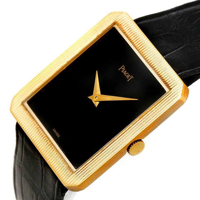 The image shows an angled view of the Piaget 9154 Men's Yellow Gold Black Dial 9154 Men's Yellow Gold Black Dial 9154 model 18K Yellow Gold Cushion Shape Men's Watch, displaying the watch face, bezel, crown, and part of the strap.