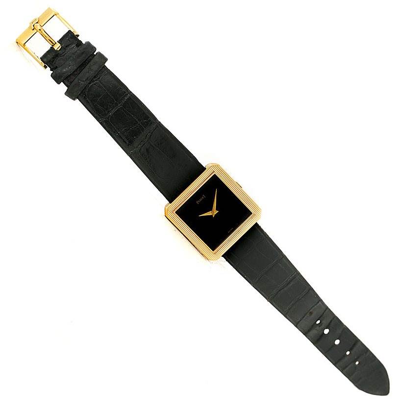 This image shows a top-down view of the Piaget 9154 Men's Yellow Gold Black Dial 9154 Men's Yellow Gold Black Dial 9154 model 18K Yellow Gold Cushion Shape Mens Watch with a black leather strap.