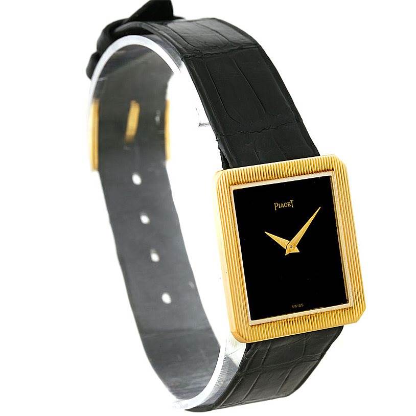 This Piaget 9154 Men's Yellow Gold Black Dial 9154 Men's Yellow Gold Black Dial 9154 model watch is shown at a slight angle, highlighting its 18K yellow gold cushion-shaped case and black leather strap.