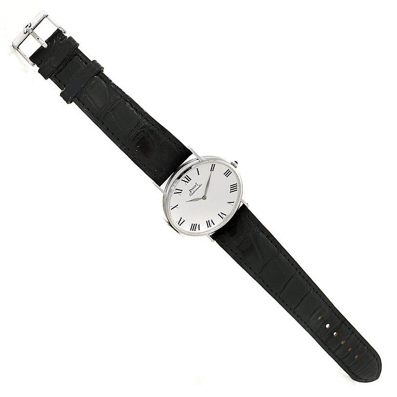 The Piaget 12501 Men's White Gold White Dial 12501 Men's White Gold White Dial 12501 18K White Gold Automatic Men's Watch is shown from a top-down angle, displaying its face, black strap, and buckle.