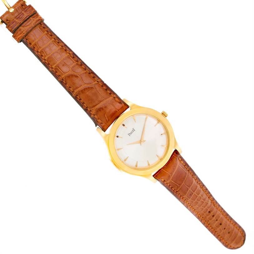 The image shows a top-down view of the Piaget 91000 Men's Yellow Gold Silver Dial 91000 Men's Yellow Gold Silver Dial 91000 18K Yellow Gold Mechanical Limited Edition Men's Watch with its dial and brown strap visible.