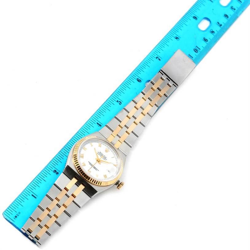 The Rolex Oysterquartz 17013 Men's Stainless Steel White Dial 17013 Men's Stainless Steel White Dial model is shown at an oblique angle, highlighting the watch face, bezel, crown, and two-tone bracelet alongside a ruler.