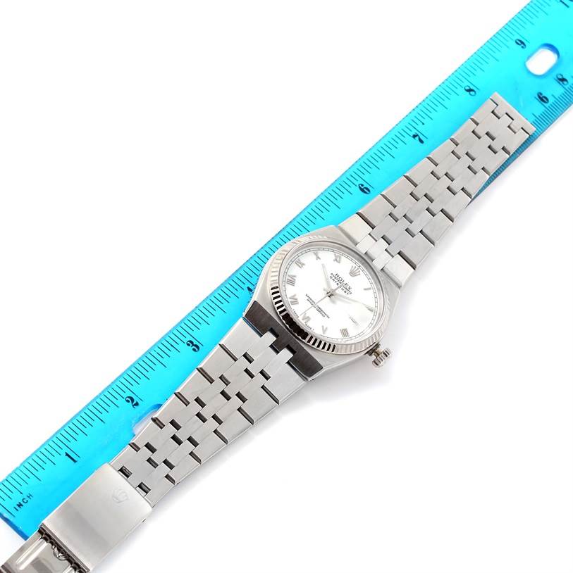 The Rolex Oysterquartz 17014 Men's Stainless Steel White Dial 17014 Men's Stainless Steel White Dial watch is shown laid flat with its face, bracelet, and crown visible, beside a ruler for scale.