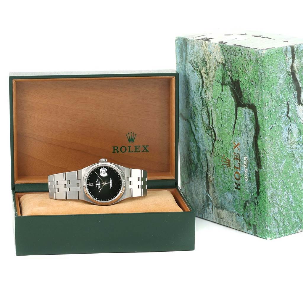 The Rolex Oysterquartz 17014 Men's Stainless Steel White Dial 17014 Men's Stainless Steel White Dial watch is shown front-facing in its open box, alongside its green and white outer packaging.