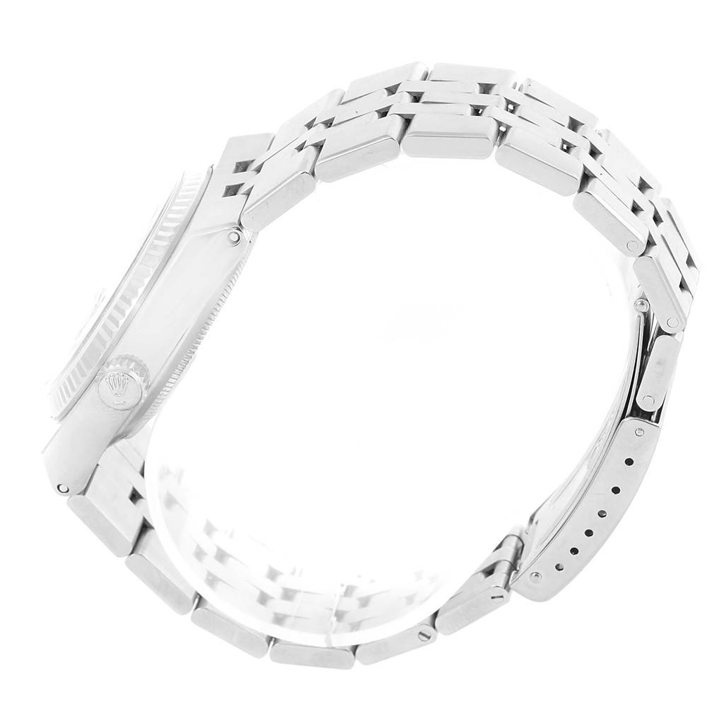 This side view of the Rolex Oysterquartz 17014 Men's Stainless Steel White Dial 17014 Men's Stainless Steel White Dial watch displays its band, clasp, and partially the case with the crown logo.