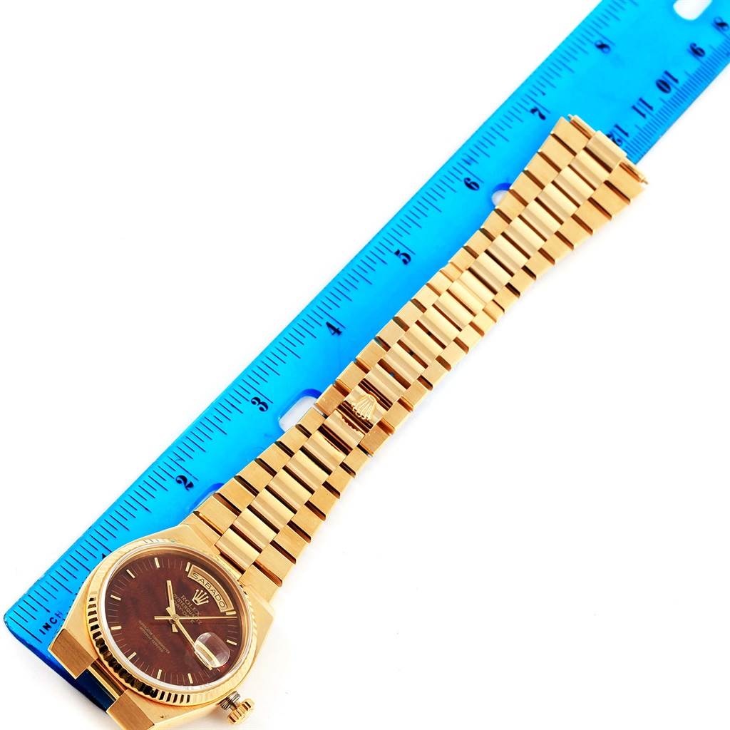 The image shows a Rolex Oysterquartz 19018 Men's Stainless Steel Brown Dial 19018 Men's Stainless Steel Brown Dial watch laid flat alongside a blue ruler, displaying the watch face, bracelet, and crown.