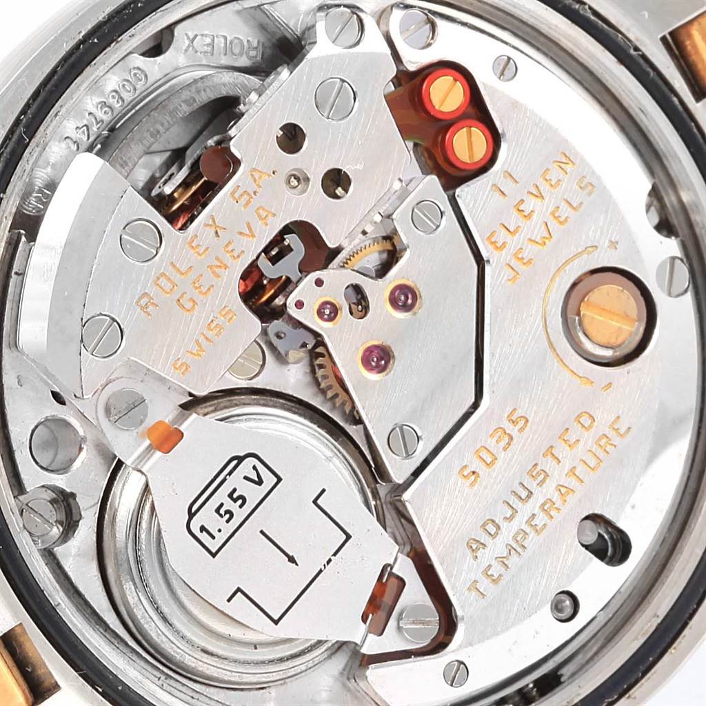 The image shows a close-up of the movement inside a Rolex Oysterquartz 17013 Men's Stainless Steel White Dial 17013 Men's Stainless Steel White Dial watch, revealing gears, screws, and inscriptions.