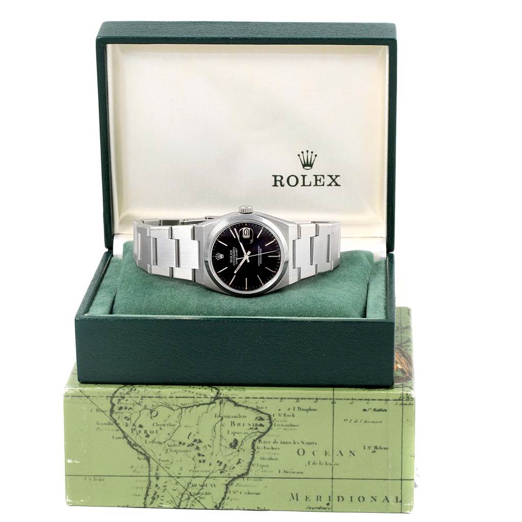 The Rolex Oysterquartz 17000 Men
s Stainless Steel Black Dial 17000 Men
s Stainless Steel Black Dial watch is shown from the front, displayed in its open green watch box with a black dial and silver bracelet.