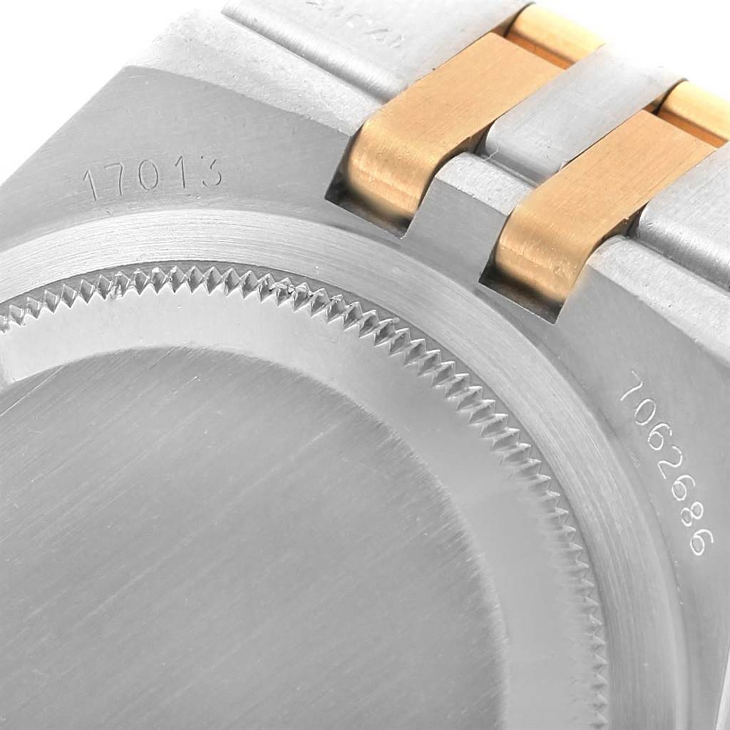 The image shows a close-up of the back case and part of the bracelet of a Rolex Oysterquartz 17013 Men's Stainless Steel Champagne Dial 17013 Men's Stainless Steel Champagne Dial watch, highlighting its brushed metal texture and serial number.