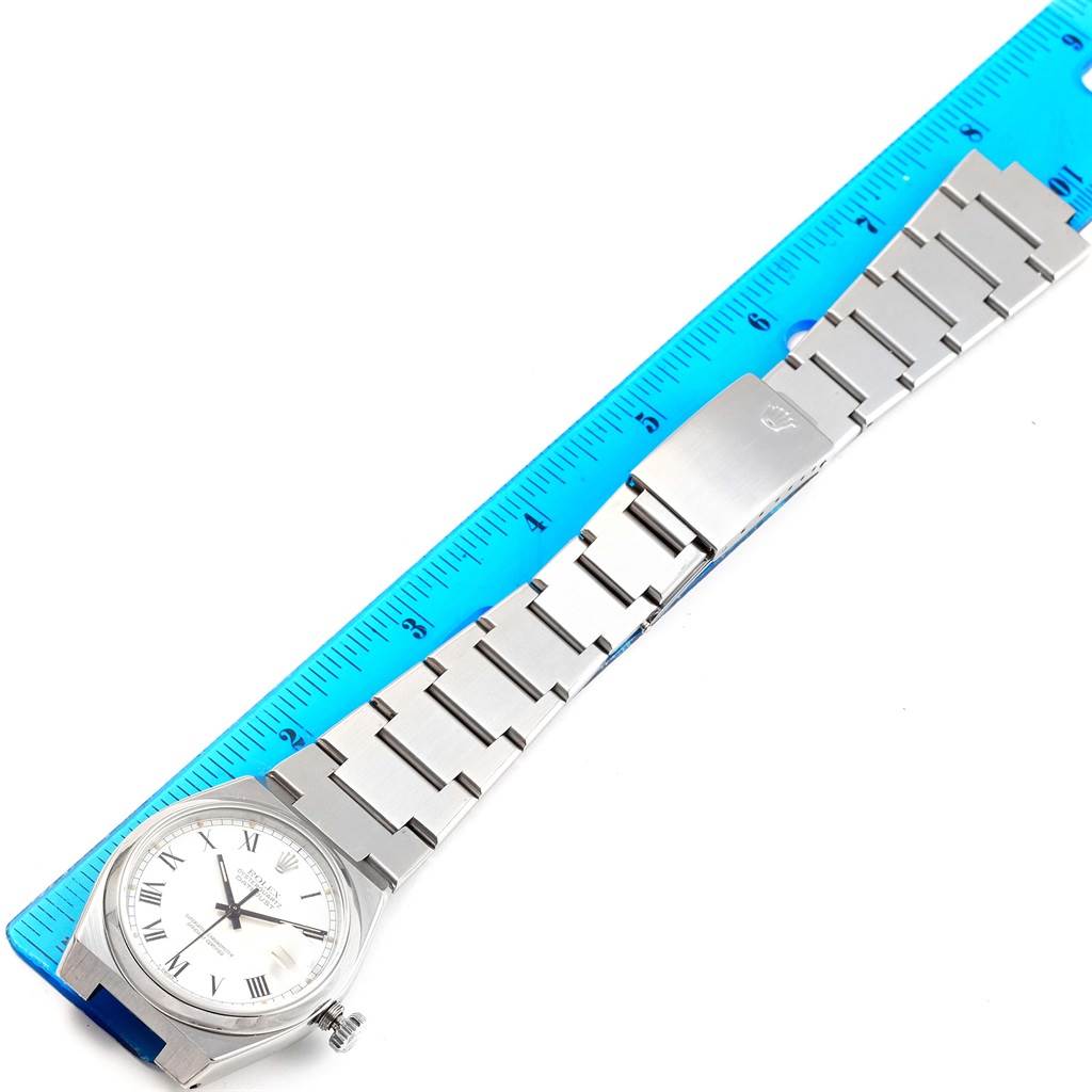 This image displays a Rolex Oysterquartz 17000 Men's Stainless Steel White Dial 17000 Men's Stainless Steel White Dial watch laid flat with its bracelet aligned next to a blue ruler.