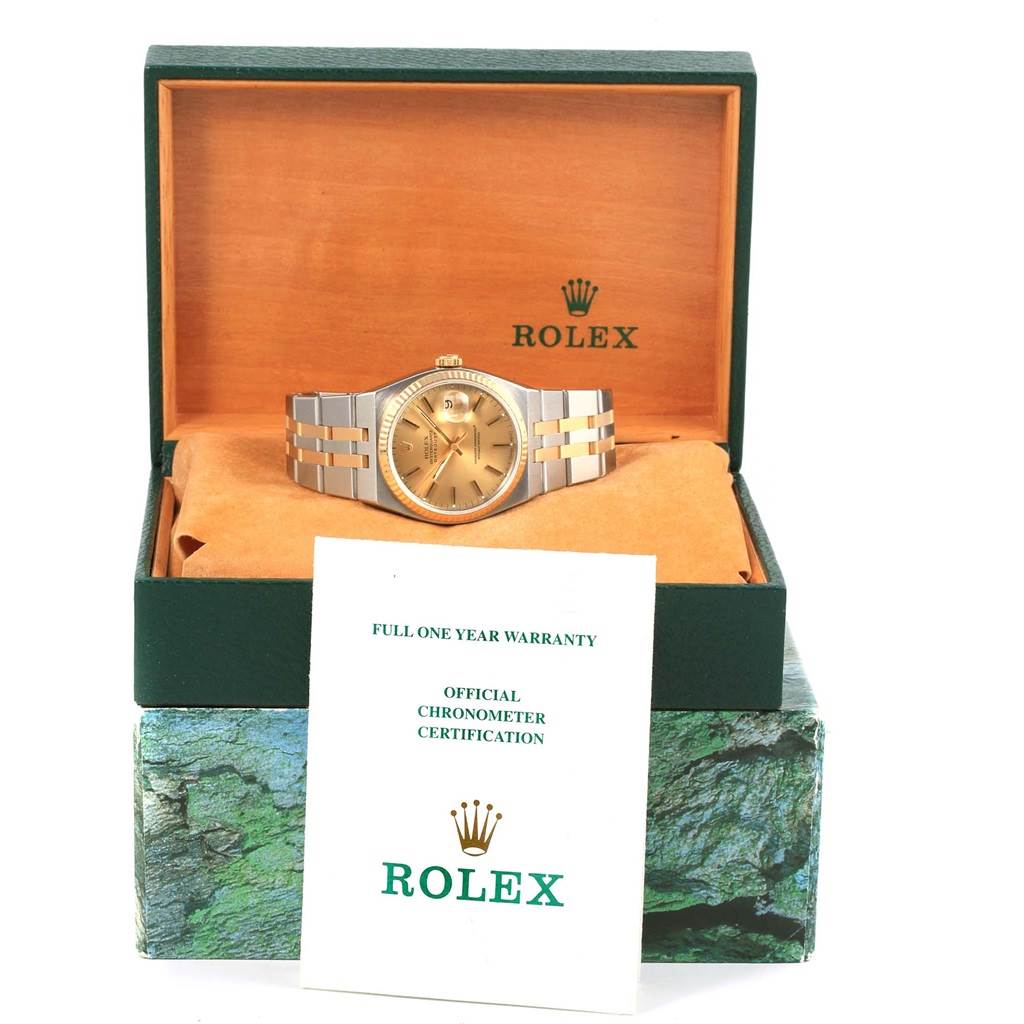 The Rolex Oysterquartz 17013 Men's Stainless Steel Champagne Dial 17013 Men's Stainless Steel Champagne Dial watch is displayed front-facing in its open box with warranty and certification documents in front.