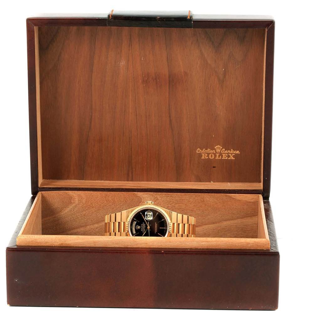 The Rolex Oysterquartz 19018 Men's Yellow Gold Black Dial 19018 Men's Yellow Gold Black Dial watch is shown from the front inside an open wooden display box.
