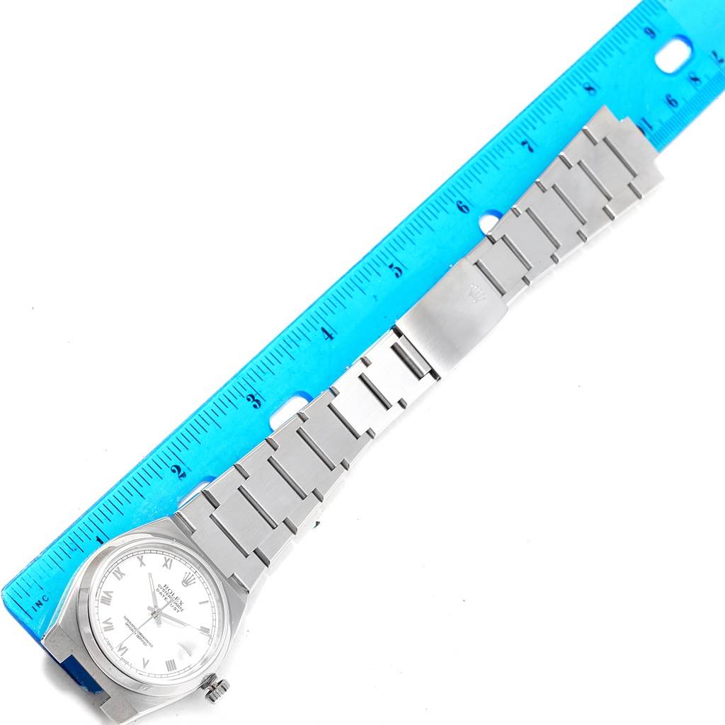 The Rolex Oysterquartz 17000 Men's Stainless Steel White Dial 17000 Men's Stainless Steel White Dial watch is shown from a top-down angle with its bracelet fully extended next to a blue ruler for scale.