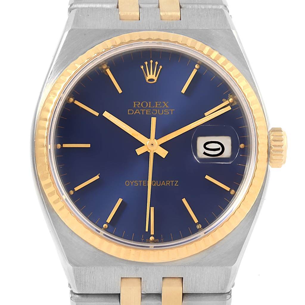 The Rolex Oysterquartz 17013 Men
s Steel and Gold (two tone) Blue Dial 17013 Men
s Steel and Gold (two tone) Blue Dial Datejust watch is shown from a front angle, highlighting its blue dial, gold bezel, and metal bracelet.