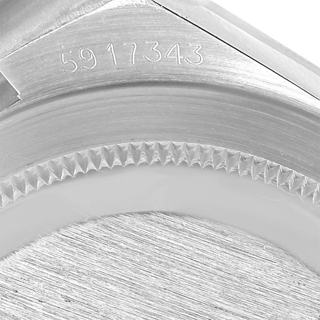 The close-up image shows the serial number and part of the bezel of an Oysterquartz model by Rolex.