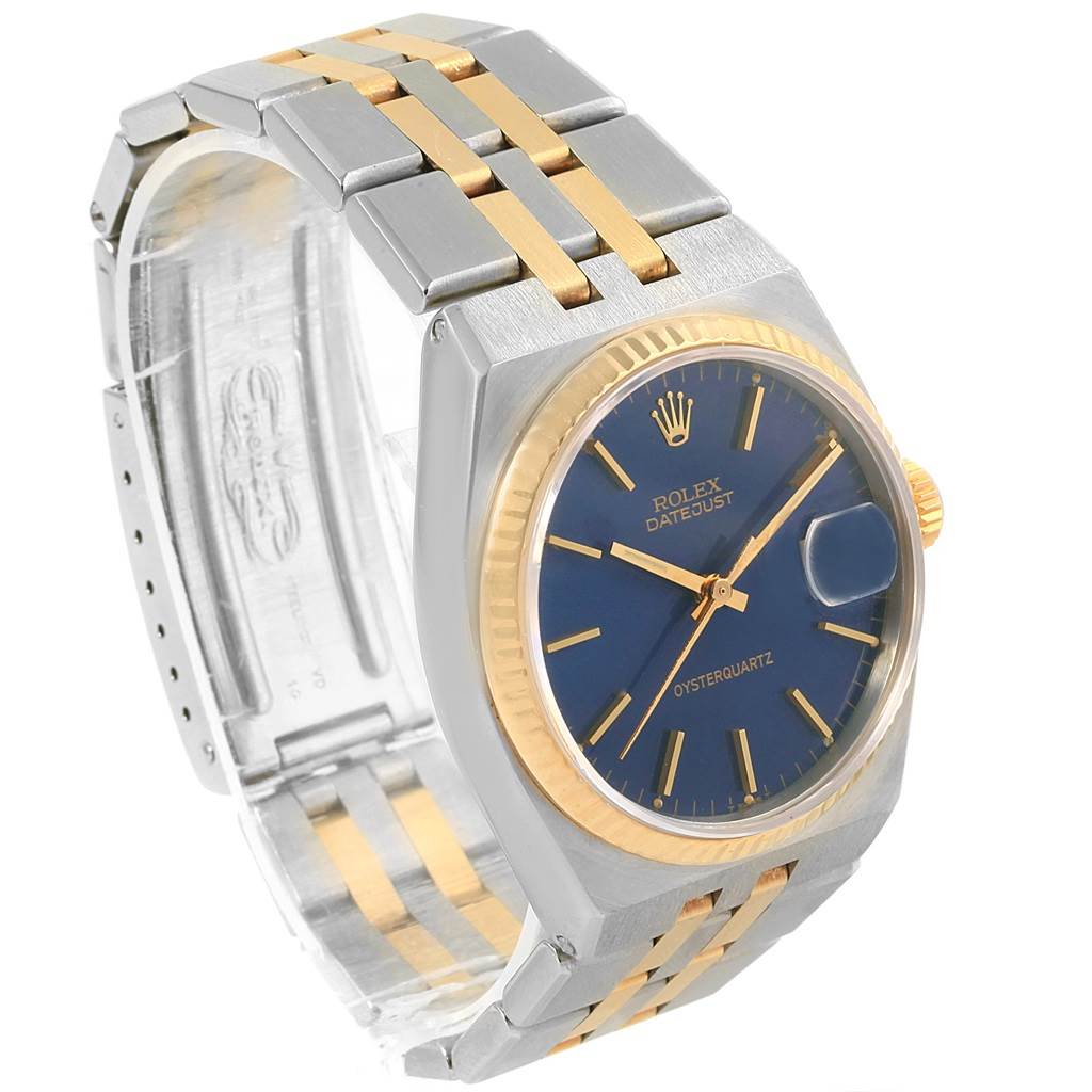 The Rolex Oysterquartz 17013 Men
s Steel and Gold (two tone) Blue Dial 17013 Men
s Steel and Gold (two tone) Blue Dial watch is shown at a three-quarter angle, highlighting its blue dial, gold bezel, and two-tone bracelet.