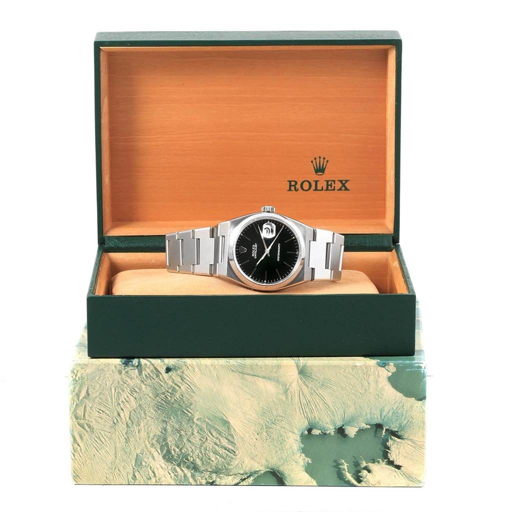 The Rolex Oysterquartz 17000 Men's Stainless Steel Black Dial 17000 Men's Stainless Steel Black Dial watch is shown from the front, inside its open green and orange Rolex box, emphasizing the dial and bracelet.