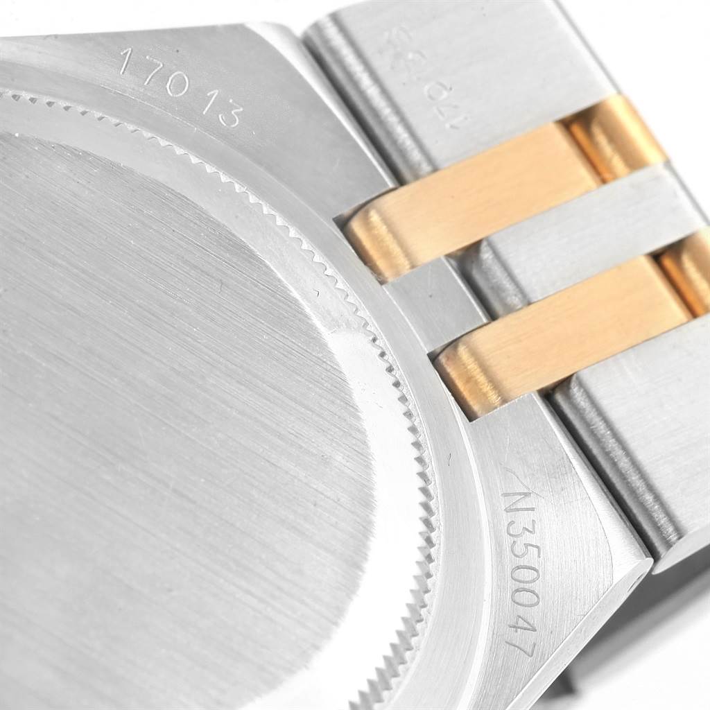 This close-up image of a Rolex Oysterquartz 17013 Men's Stainless Steel White Dial 17013 Men's Stainless Steel White Dial watch shows the model number, part of the case back, and the metal bracelet with gold accents.